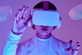 A person wearing a VR headset interacts with a virtual environment, surrounded by futuristic, glowing shapes. The scene represents the immersive experience of the metaverse. The image is used to convey the concept of digital innovation, highlighting Vertech Digital's focus on the future of virtual spaces and technology.