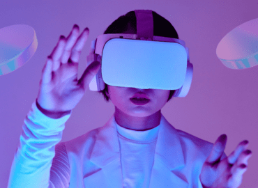 A person wearing a VR headset interacts with a virtual environment, surrounded by futuristic, glowing shapes. The scene represents the immersive experience of the metaverse. The image is used to convey the concept of digital innovation, highlighting Vertech Digital's focus on the future of virtual spaces and technology.